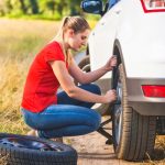 Photo or woman changing flat tire