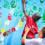 Photo of Ghanaian boy adding handprint to school