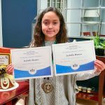 Photo of Isabella proudly celebrating her spelling bee win.