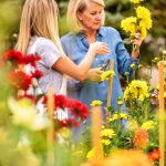 Photo of Amy Dismuke and her daughter Ann inspecting flowers.