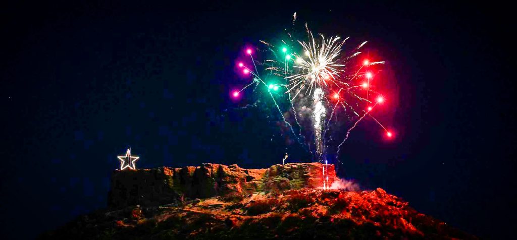 fireworks over rock formation at night and star-shaped light