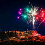 fireworks over rock formation at night and star-shaped light