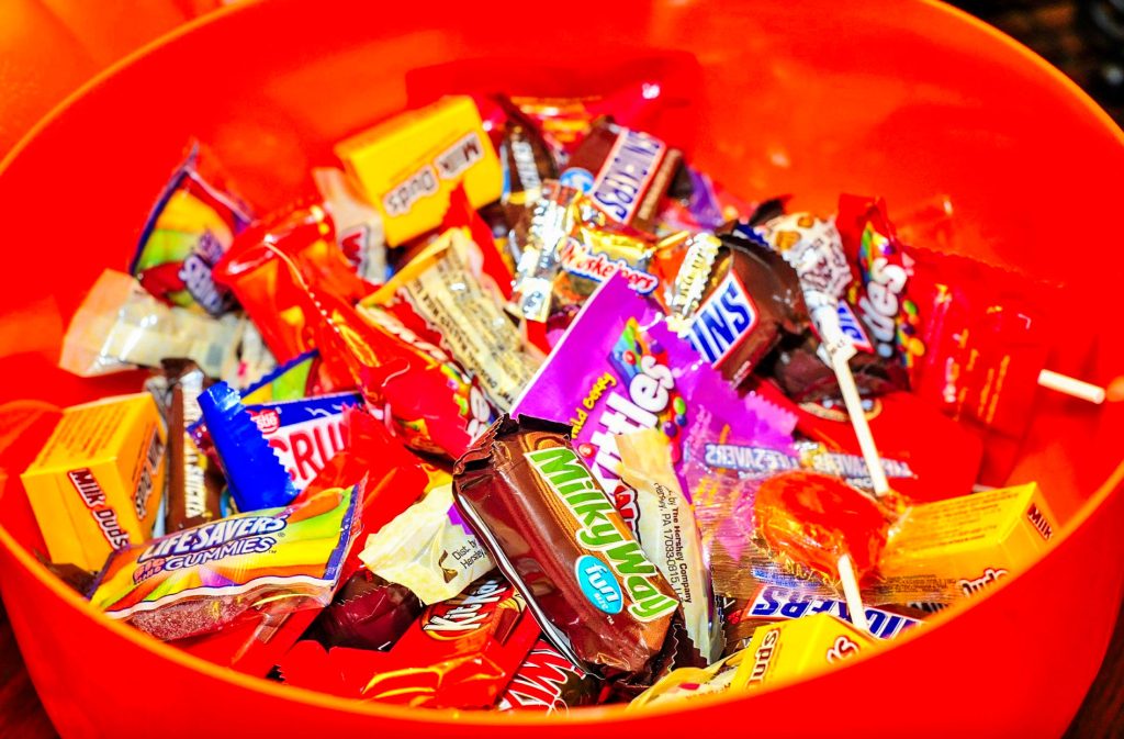 orange bowl of various packaged candy bars