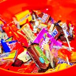 orange bowl of various packaged candy bars