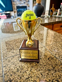 photo of trophy cup with tennis ball on top